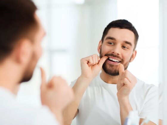 Persona cuidando su salud bucal para evitar riesgos con el biofilm - Clínica dental en Oviedo